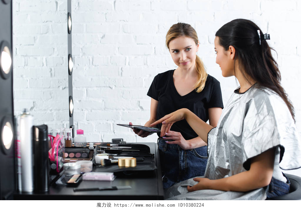 年轻女子指着化妆师手上的颜色年轻女子指着化妆师手上的颜色调色板